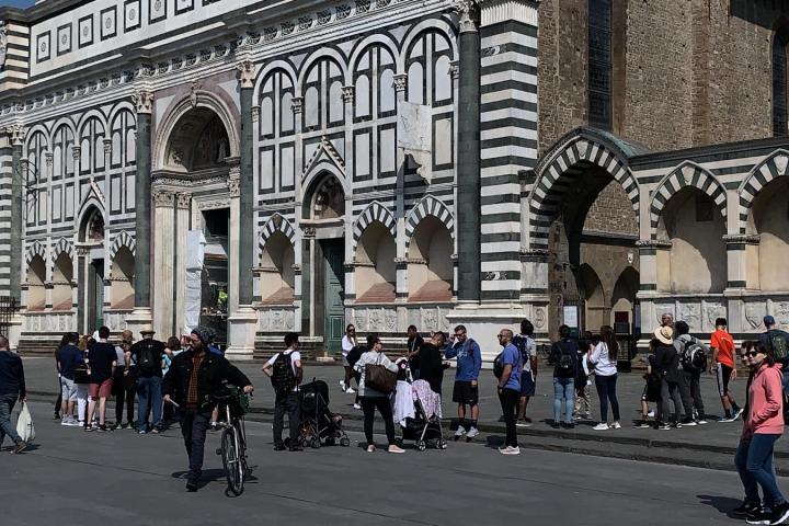a group of people walking down a street in front of a building