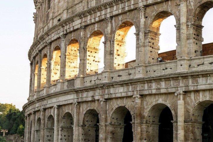 a large stone building with Colosseum in the background